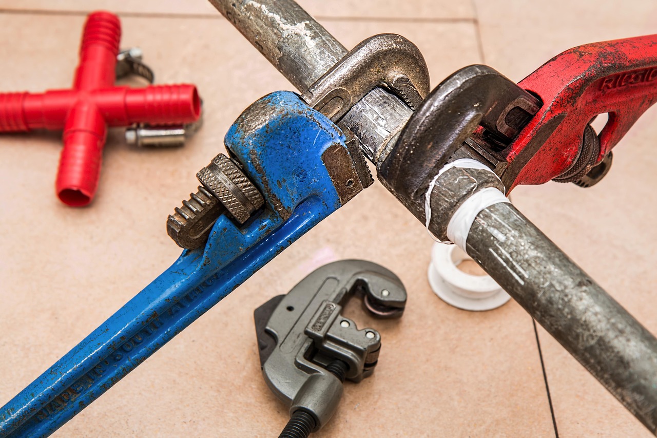 Plumbing tools and copper pipe on a workbench