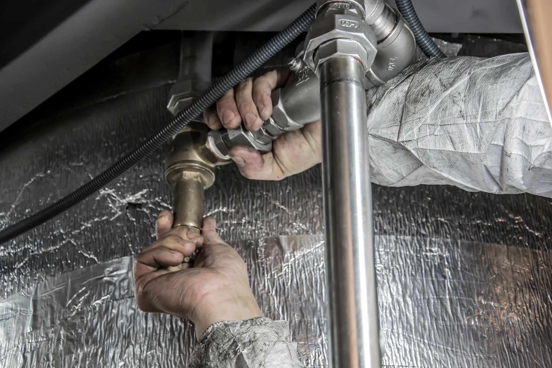 Plumber tightening a fitting on a residential job
